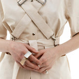 Close up of Emily Millichip Bondage Shirt in natural seeded cotton canvas, showing cross straps, stainless steel buckles and waist belt.
