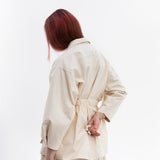 Back view of Gravity Field Jacket in natural seeded cotton canvas, cinched at the waist