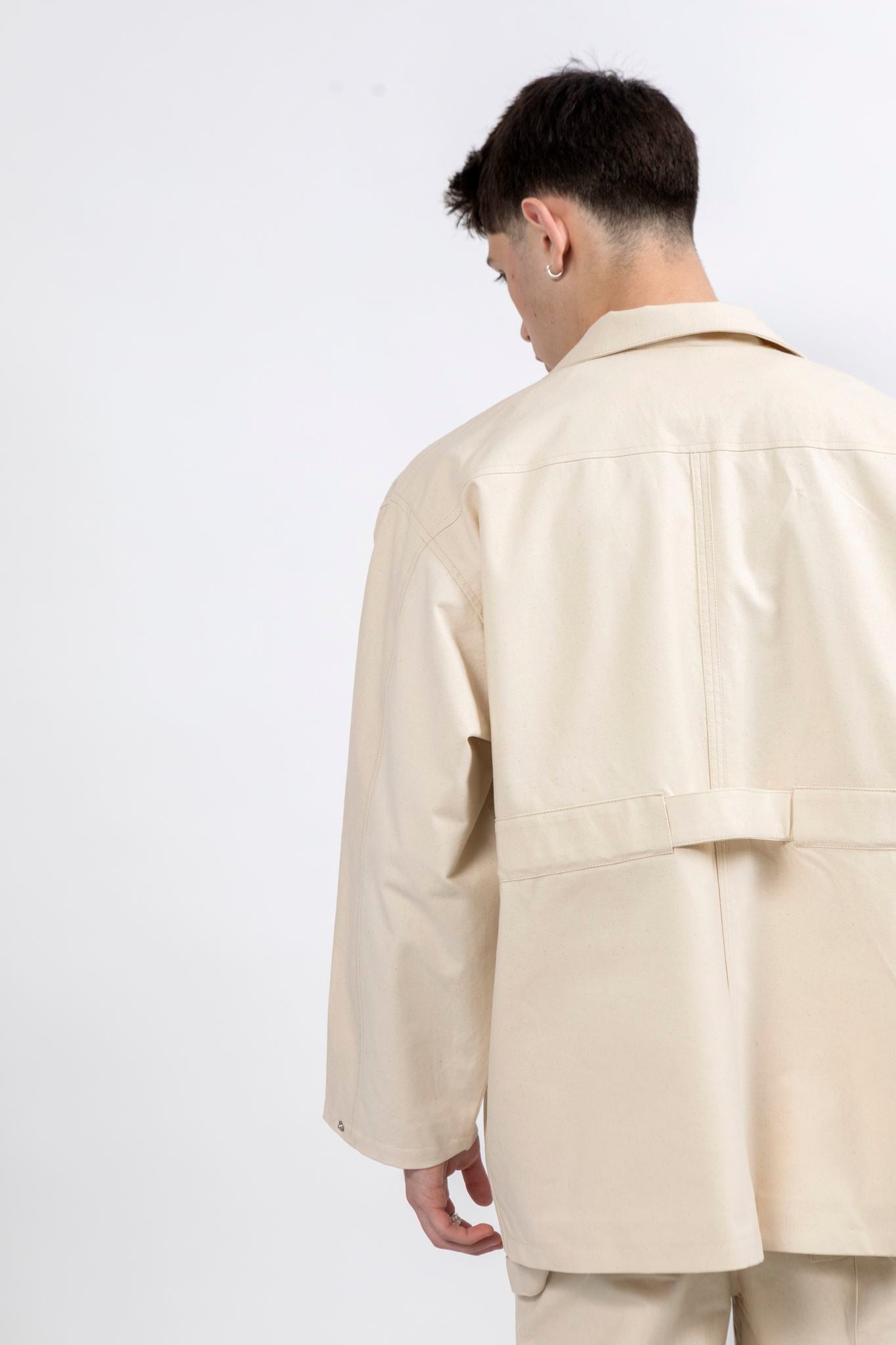 Back view of the Gravity Field Jacket in natural seeded cotton canvas with full-length sleeves
