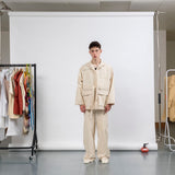 Front view of gravity field jacket in natural seeded canvas, worn loose and boxy
