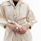 Gravity Field Jacket in natural seeded canvas, showing stainless steel hardware and cinched waist